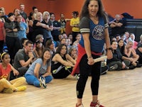a woman holding a baton in front of a crowd of people