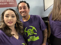 two people posing for a photo wearing purple shirts